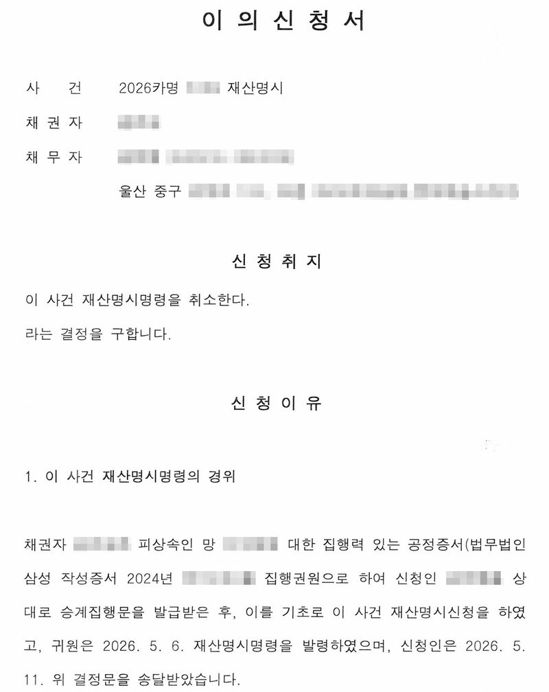 이의신청서. 사건 2026카명 재산명시, 채권자, 채무자(울산 중구). 신청취지 — 이 사건 재산명시명령을 취소한다라는 결정을 구함. 신청이유 — 채권자는 피상속인 망인에 대한 집행력 있는 공정증서(법무법인 작성증서 2024년)를 집행권원으로 하여 신청인을 상대로 승계집행문을 발급받은 후 재산명시신청을 하였고, 법원은 2026. 5. 6. 재산명시명령을 발령, 신청인은 2026. 5. 11. 결정문을 송달받음. 당사자 이름과 주민등록번호, 주소 가운데 구 뒤의 자리, 사건번호와 공정증서 번호의 숫자, 판사 이름, 도장과 QR은 가렸다.