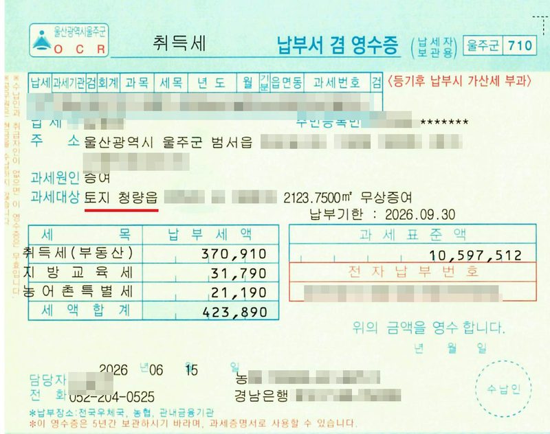 취득세 납부서 겸 영수증(울주군). 납세번호(가림), 납세자·주민등록번호(가림), 주소 울산광역시 울주군 범서읍(뒷자리 가림), 과세원인 증여, 과세대상 토지 청량읍(빨간 밑줄, 지번 가림) 2123.7500㎡ 무상증여, 납부기한 2026.09.30. 세목별 납부세액 — 취득세(부동산) 370,910, 지방교육세 31,790, 농어촌특별세 21,190, 세액합계 423,890. 과세표준액 10,597,512. 전자납부번호(가림). 2026 06 15. 담당자(이름 가림) 전화 052-204-0525, 가상계좌번호(가림).