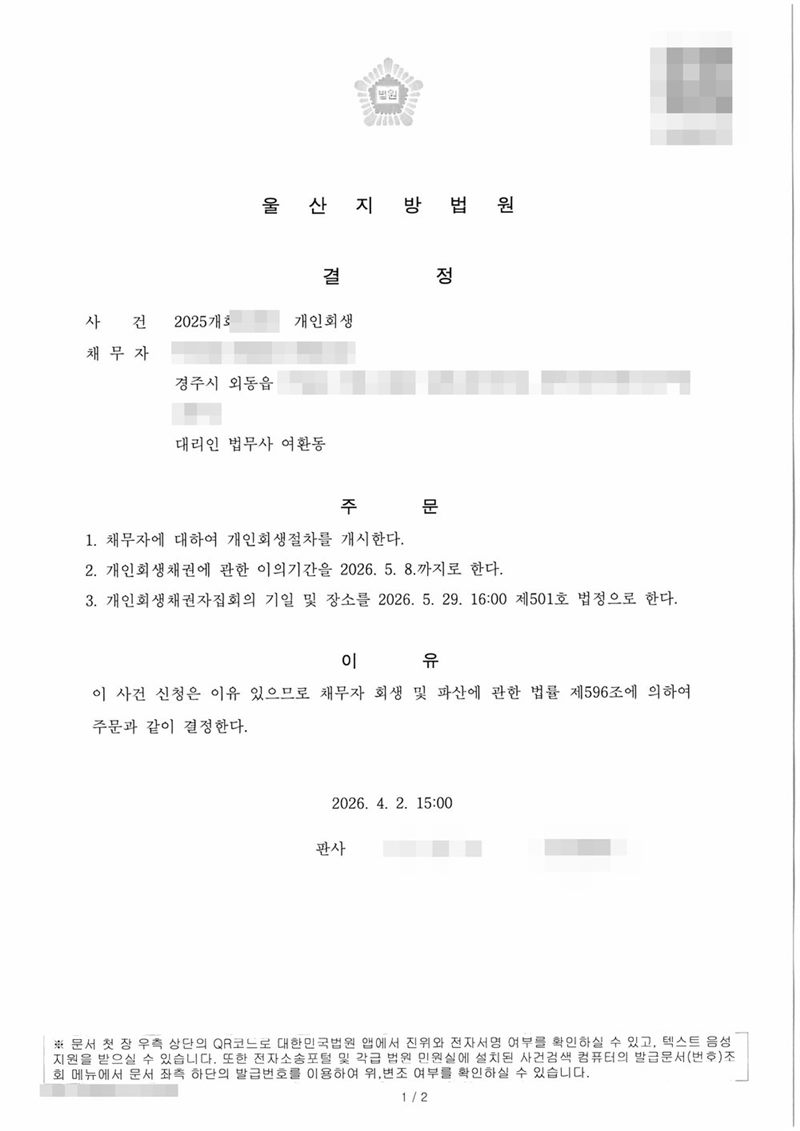 울산지방법원 개인회생절차 개시결정(부부 가운데 한 사람). 채무자 주소 경주시 외동읍. 주문은 1. 개인회생절차를 개시한다 2. 이의기간 3. 채권자집회 기일 및 장소(제501호 법정). 이유는 제596조. 채무자 이름·주민등록번호·주소 가운데 시·읍·면 뒤의 자리·사건번호 숫자·판사와 법원주사(보) 이름·QR코드·발급번호는 가렸다.