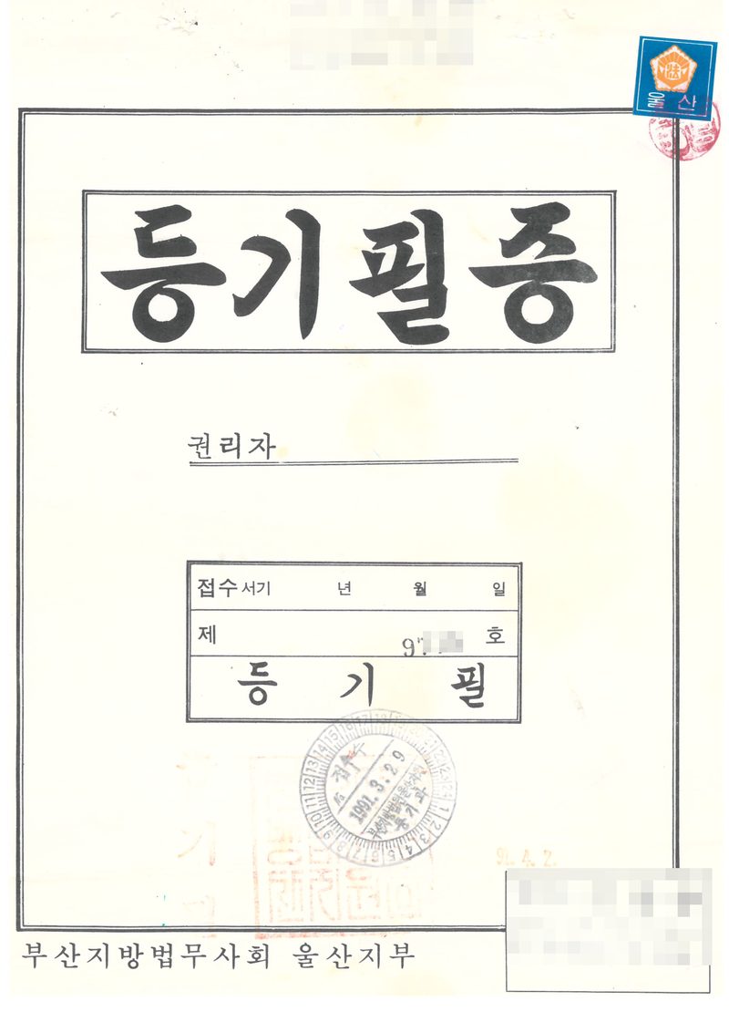 옛 등기필증 표지. 큰 글씨로 「등기필증」, 권리자 칸, 접수 서기 년 월 일 제 호(번호 가림) 「등기필」 도장, 1991년 등기소 접수인, 부산지방법무사회 울산지부. 위쪽과 오른쪽 아래의 다른 법무사 이름·주소·전화번호는 가렸다.