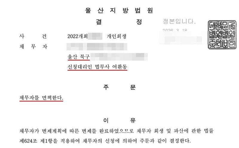 울산지방법원의 개인회생 면책결정. 오른쪽 위에 정본입니다 도장. 채무자 주소의 시·구는 울산 북구, 신청대리인 법무사 여환동. 주문은 채무자를 면책한다는 한 줄. 이유는 채무자가 변제계획에 따른 변제를 완료하였으므로 채무자 회생 및 파산에 관한 법률 제624조 제1항을 적용하여 채무자의 신청에 의하여 주문과 같이 결정한다는 것. 사건번호 숫자, 채무자 이름·주민등록번호·상세 주소, 법원주사보 이름은 가렸다.