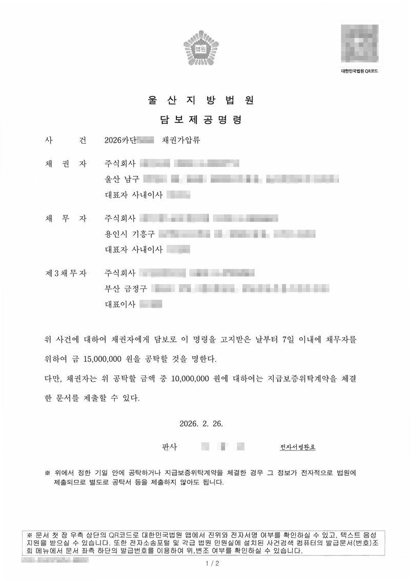 울산지방법원 담보제공명령. 사건 채권가압류, 채권자 주식회사(울산 남구), 채무자 주식회사(용인시 기흥구), 제3채무자 주식회사(부산 금정구). 「위 사건에 대하여 채권자에게 담보로 이 명령을 고지받은 날부터 7일 이내에 채무자를 위하여 금 15,000,000원을 공탁할 것을 명한다. 다만, 채권자는 위 공탁할 금액 중 10,000,000원에 대하여는 지급보증위탁계약을 체결한 문서를 제출할 수 있다.」 2026. 2. 26. 판사, 전자서명완료. 상호·법인등록번호·주소 뒷자리·대표자 이름, 사건번호 숫자, 판사 이름, QR코드·발급번호는 가렸다.