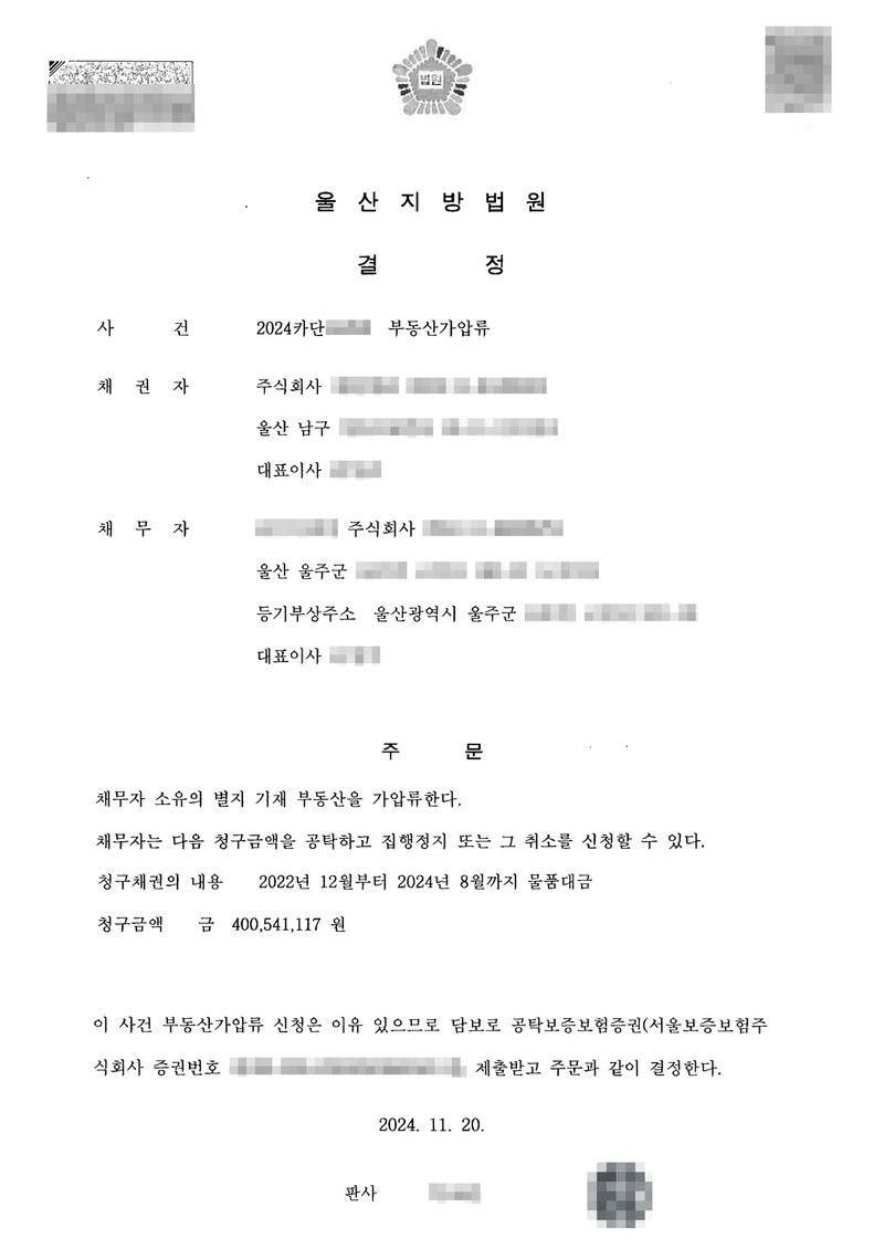 울산지방법원 결정. 사건 부동산가압류, 채권자 주식회사(울산 남구), 채무자 주식회사(울산 울주군, 등기부상주소 울산광역시 울주군). 주문 — 채무자 소유의 별지 기재 부동산을 가압류한다. 채무자는 다음 청구금액을 공탁하고 집행정지 또는 그 취소를 신청할 수 있다. 청구채권의 내용 2022년 12월부터 2024년 8월까지 물품대금, 청구금액 400,541,117원. 이유 — 담보로 공탁보증보험증권(서울보증보험주식회사)을 제출받고 주문과 같이 결정한다. 2024. 11. 20. 판사. 당사자 이름(상호)과 주민·법인등록번호, 주소 가운데 시·구·군 뒤의 자리, 사건번호 숫자, 보증보험 증권번호, 법관 이름과 도장, QR코드·발급번호·위변조 방지 바코드는 가렸다.