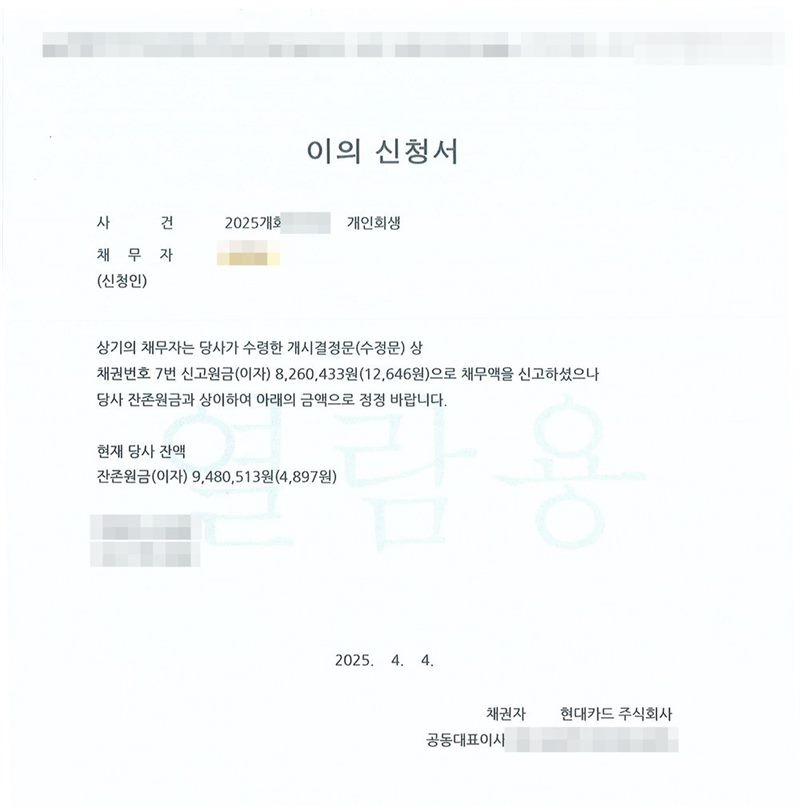 카드회사가 울산지방법원에 낸 이의신청서. 채무자가 수령한 개시결정문(수정문)상 채권번호의 신고원금(이자)으로 채무액을 신고하셨으나 당사 잔존원금과 상이하여 아래의 금액으로 정정 바란다는 내용과 현재 당사 잔액. 끝에 채권자 카드회사. 채무자 이름·사건번호·카드회사 담당자 이름과 전화번호·공동대표이사 이름은 가렸다.