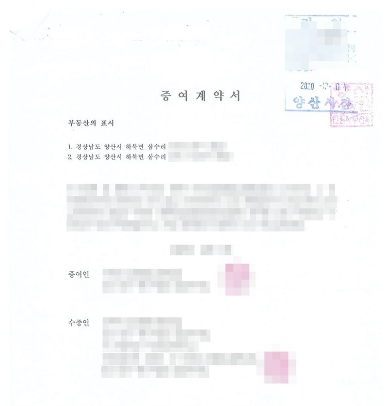 증여계약서. 부동산의 표시 1. 경상남도 양산시 하북면 창고용지 2. 경상남도 양산시 하북면 창고용지. 증여인과 수증인(미성년자, 법정대리인 친권자 모). 오른쪽 위에 부동산등기특별조치법에 따른 검인 도장과 양산시장 직인. 이름과 주민등록번호, 주소 가운데 시·구 뒤의 자리, 등록기준지, 사건번호 숫자, 지번, 금액, 판사·법원주사 이름과 도장, 서명·도장, QR코드·발급번호·위변조 방지 바코드는 가렸다.